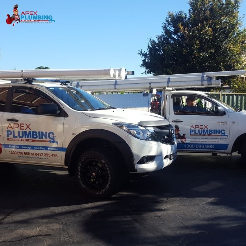 Two Apex Plumbing service trucks with phone numbers for drainage, gasfitting, and hot water services in Sydney