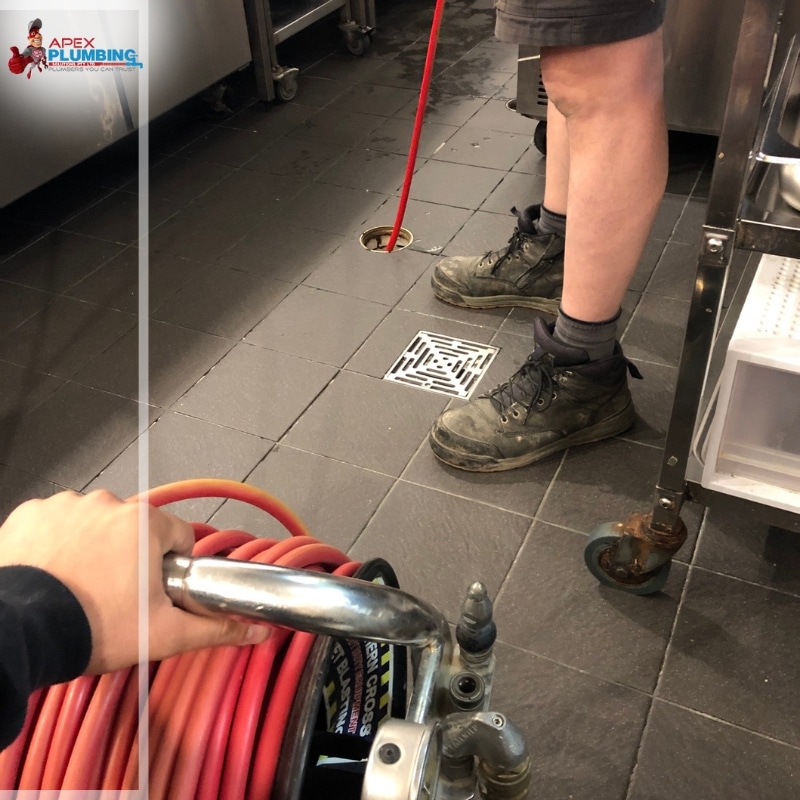 Plumbers using an equipment to clear blocked drain in the kitchen